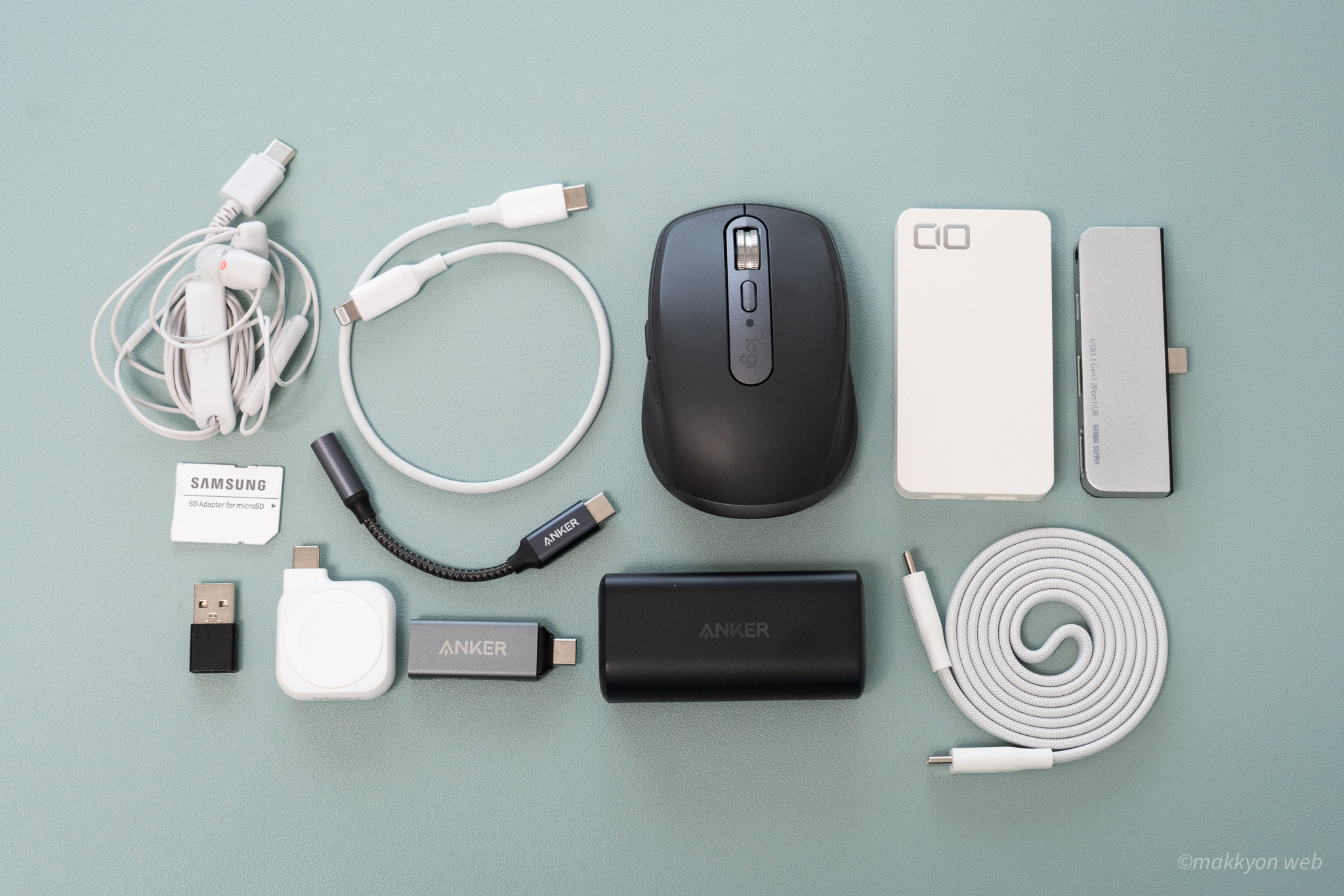 カバコの中に詰め込まれた、ワイヤレスマウスやUSB充電器、ケーブルや変換アダプタを並べた